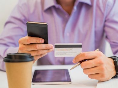 hombre pagando su tarjeta de crédito en su celular