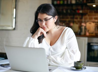 mujer concentrada revisando algo en su laptop