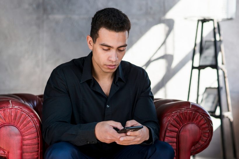 hombre concentrado revisando su celular