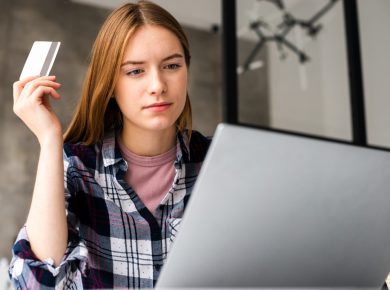 mujer concentrada revisando información de su tarjeta de crédito
