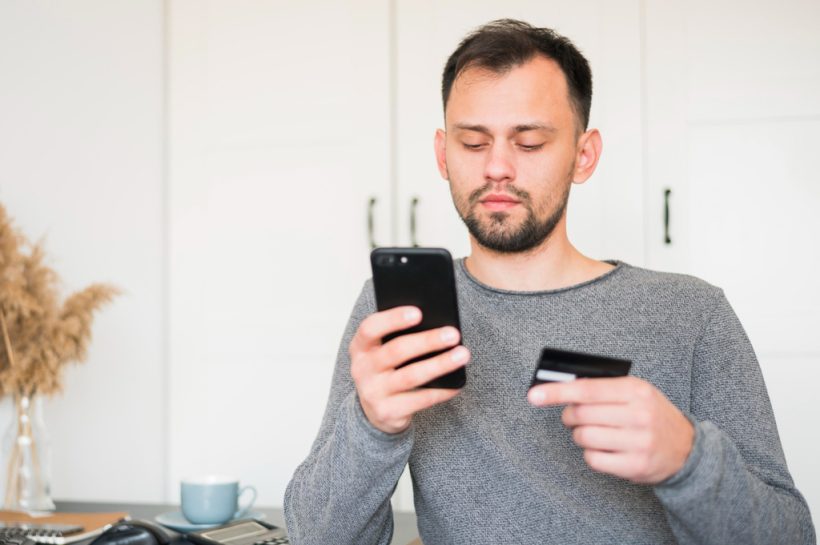 hombre realizando una transferencia bancaria por su celular