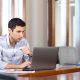 hombre revisando sus finanzas en la laptop