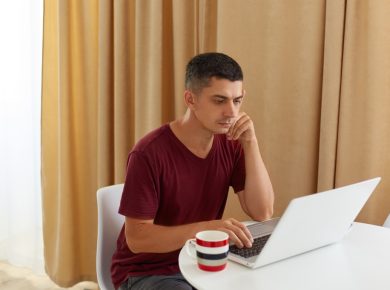 hombre dubitativo revisando una información en su laptop
